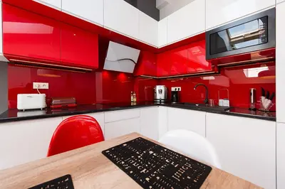 a red and white kitchen with a wooden table and chairs at Cozy and Large 62 m2 Apartment with Air Conditioning, Old Town in Kraków