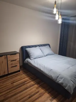 a small bedroom with a bed and a dresser at Apartament N89 Wiślane Tarasy in Kraków
