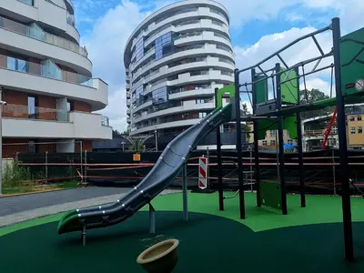 a playground with a slide in front of a building at Apartament N89 Wiślane Tarasy in Kraków