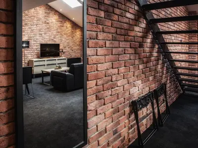 a brick wall in a room with a mirror at Hotel Betmanowska Main Square Residence Adults Only in Kraków