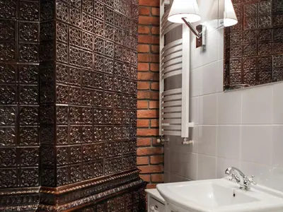 a bathroom with a sink and a tile wall at Hotel Betmanowska Main Square Residence Adults Only in Kraków