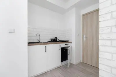 a kitchen with white walls and a counter and a door at Cracow Miodowa 42 Elegant Studios by Noclegi Renters in Kraków