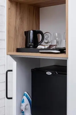 a shelf with a coffee pot on top of a refrigerator at Cracow Miodowa 42 Elegant Studios by Noclegi Renters in Kraków