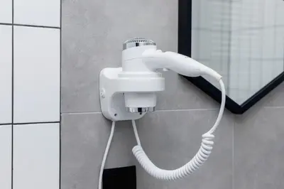 a white blow dryer on a wall in a bathroom at Cracow Miodowa 42 Elegant Studios by Noclegi Renters in Kraków