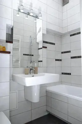 a white bathroom with a sink and a tub at TiB Apartament na Kazimierzu in Kraków