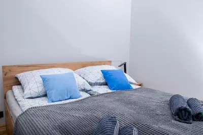 a bed with blue and white pillows on it at TiB Apartament na Kazimierzu in Kraków