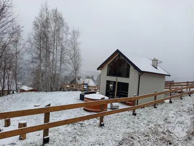 a house covered in snow in front of a fence at Brzozowe Zacisze in Lachowice