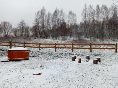 a snow covered field with a fence and a tub at Brzozowe Zacisze in Lachowice