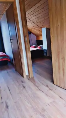 a room with a bed and a wooden floor at Brzozowe Zacisze in Lachowice