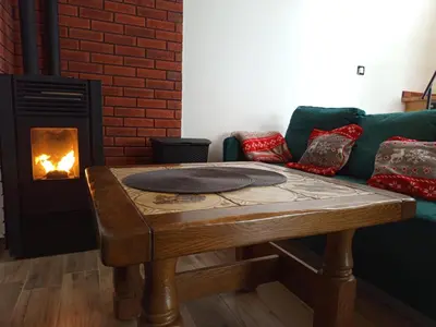 a living room with a couch and a table with a fireplace at Brzozowe Zacisze in Lachowice