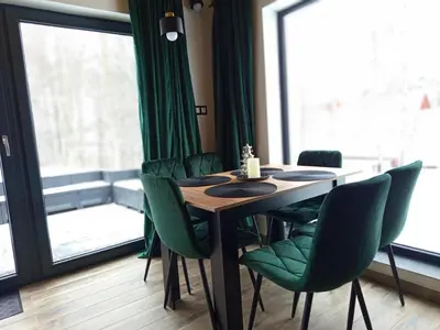 a dining room with a table and green chairs at Brzozowe Zacisze in Lachowice
