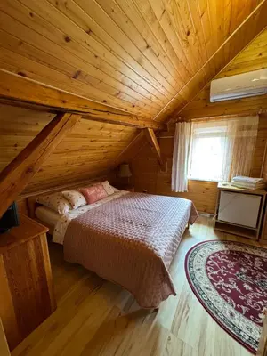 a bedroom with a bed in a wooden cabin at Gościniec Grek Zorba - pokoje i domki 4 osobowe - 16km od Zator Energylandia in Inwałd