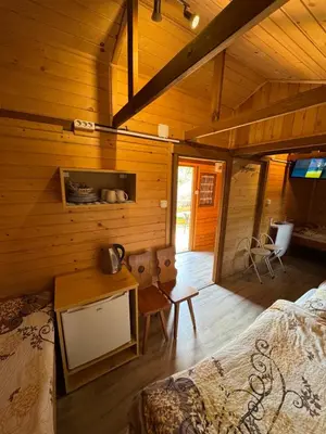 a log cabin with a bed and a desk in it at Gościniec Grek Zorba - pokoje i domki 4 osobowe - 16km od Zator Energylandia in Inwałd