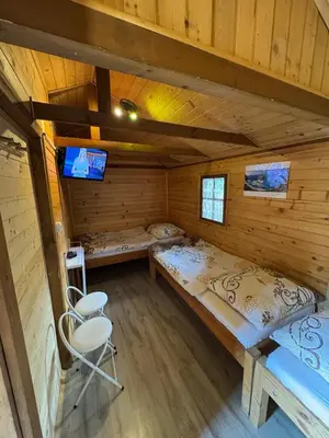 a room with a bed and a chair in a cabin at Gościniec Grek Zorba - pokoje i domki 4 osobowe - 16km od Zator Energylandia in Inwałd