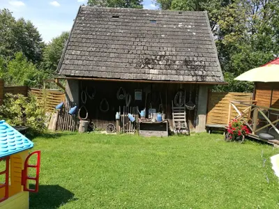 a small house with a black roof on a yard at Gościniec Grek Zorba - pokoje i domki 4 osobowe - 16km od Zator Energylandia in Inwałd