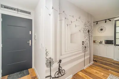 a hallway with a door with a bike on the wall at Prądnik Biały Apt - Parks Nearby - by Rentujemy in Kraków