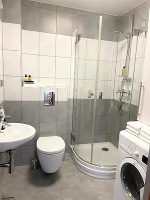 a bathroom with a shower and a toilet and a sink at No̱410 City View Apartment & free private parking in Kraków