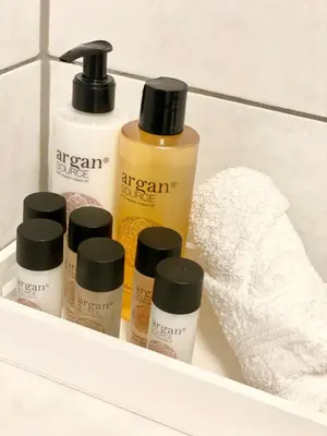 a shelf with four bottles of moisturizers and a towel at No̱410 City View Apartment & free private parking in Kraków