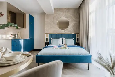 a bedroom with a blue bed and a table at Millou by StayLab in Kraków