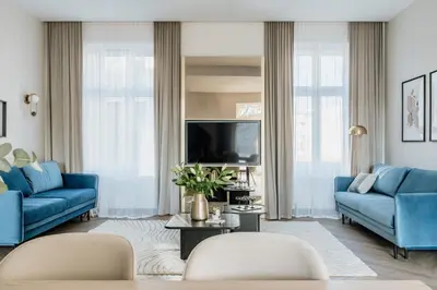 a living room with blue couches and a tv at Millou by StayLab in Kraków