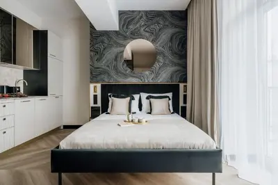 a bedroom with a large bed and a wall at Millou by StayLab in Kraków
