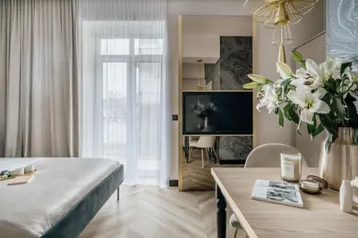 a bedroom with a bed and a tv and a table at Millou by StayLab in Kraków