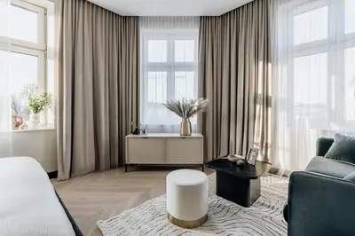 a living room with a bed and a couch at Millou by StayLab in Kraków