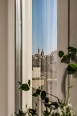 a view of a city from a window with a plant at Millou by StayLab in Kraków