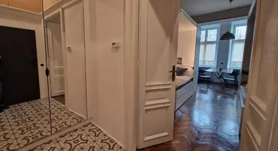 a hallway with a door to a room with a table at Noce i Dnie in Kraków