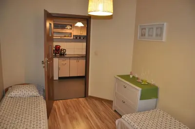 a small room with two beds and a kitchen at Topola in Kraków