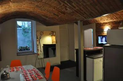 a kitchen and dining room with a table and a refrigerator at Topola in Kraków