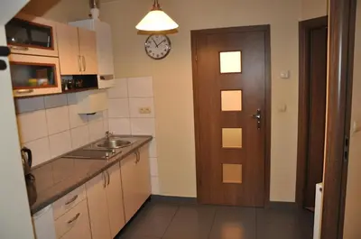 a kitchen with a sink and a clock on the wall at Topola in Kraków
