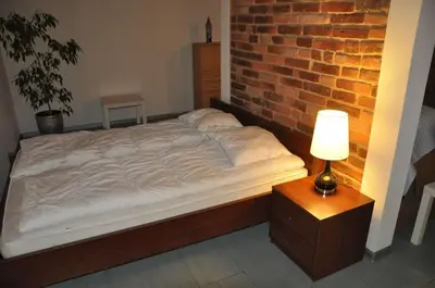 a bed in a room with a brick wall at Topola in Kraków
