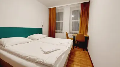 a bedroom with a white bed with a green headboard at Korona Rooms in Kraków