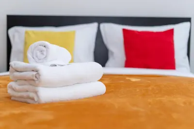 a pile of towels on a table in a bedroom at Cystersów Charming Apartment by BookingHost in Kraków