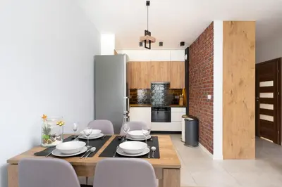 a kitchen and dining room with a table and chairs at Cystersów Charming Apartment by BookingHost in Kraków