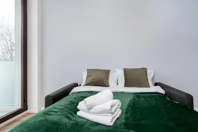 a bed with white towels on top of it at Cystersów Charming Apartment by BookingHost in Kraków