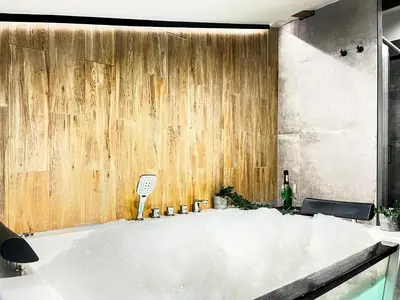 a bath tub in a room with a wooden wall at Apartment Premium Jacuzzi, Old Town Cracow in Kraków