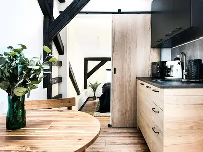 a kitchen with a wooden table and a vase of flowers at Apartment Premium Jacuzzi, Old Town Cracow in Kraków