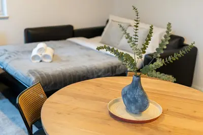 a wooden table with a blue vase on top of it at Apartments Deluxe Cannes 51 by BookingHost in Kraków