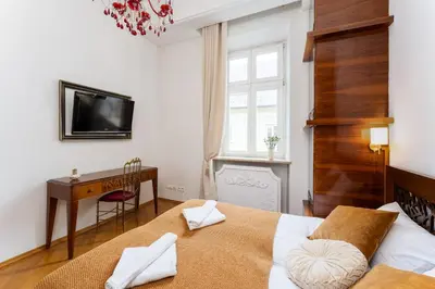 a bedroom with a bed and a desk and a television at Św Tomasza Old Town, Sun & Snow in Kraków