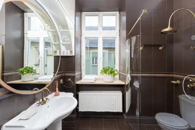 a bathroom with a sink and a shower and a mirror at Św Tomasza Old Town, Sun & Snow in Kraków