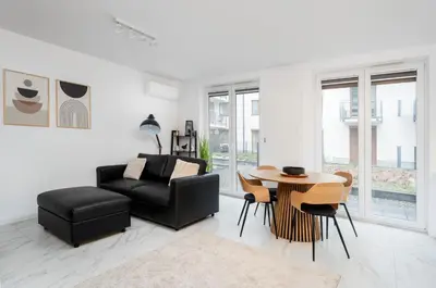 a living room with a black couch and a table at Apartments Deluxe Amsterdam 02 by BookingHost in Kraków