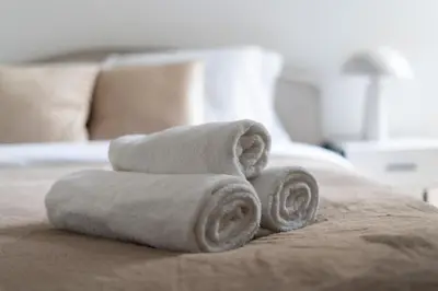 a pile of towels sitting on top of a bed at Apartments Deluxe Amsterdam 02 by BookingHost in Kraków