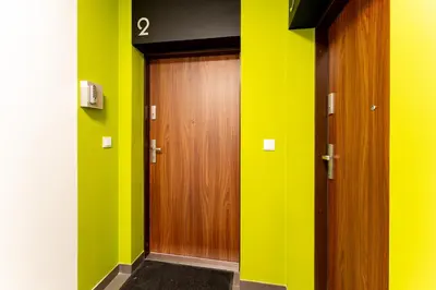 a hallway with two wooden doors and green walls at Apartments Deluxe Amsterdam 02 by BookingHost in Kraków