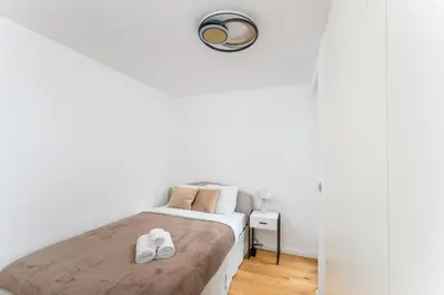 a white bedroom with a bed with white shoes on it at Apartments Deluxe Amsterdam 02 by BookingHost in Kraków