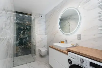 a bathroom with a sink toilet and a mirror at Apartments Deluxe Amsterdam 02 by BookingHost in Kraków