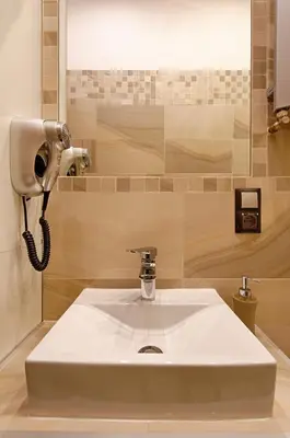 a white sink in a bathroom with a phone at Krakow Views - Stylish Apartments in Kazimierz in Kraków