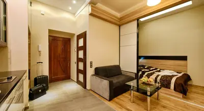 a bedroom with a bed and a chair and a table at Krakow Views - Stylish Apartments in Kazimierz in Kraków