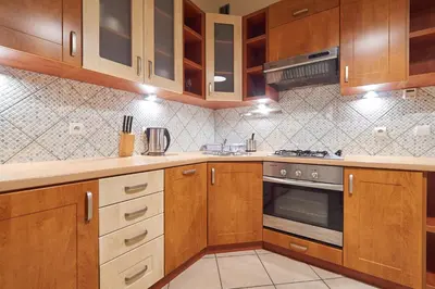 a kitchen with wooden cabinets and a stove at Krakow Views - Stylish Apartments in Kazimierz in Kraków